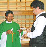 photo of Fr. Abd&oacute;n Ortiz presenting catechist Jorge Miramontes with certificate, cross, and pin