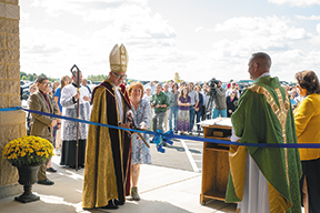 Bishop cuts ribbon at new school.