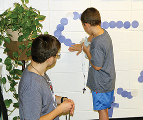 Totus Tuus leader Michael 
Milbrath helps youth learn about the Rosary. (Catholic Herald file photo)