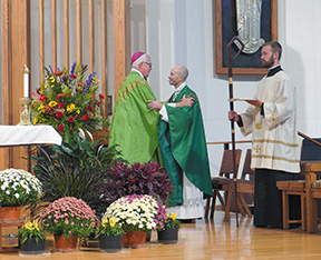 Bishop Donald J. Hying of Madison, left, congratulates Fr. Chad Droessler during Father Droessler’s installation Mass as pastor of St. Jane Frances de Chantal Parish at St. John Vianney Church in Janesville. (Catholic Herald photo/Kris Kranenburg)