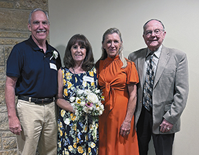 Gary and Jeanne Rusch, left, celebrate their 50th wedding anniversary at the annual diocesan marriage celebration recently held at St. Francis Xavier Church in Cross Plains. Jeanne is holding a replica of her wedding bouquet from 1975. Pictured on the right are Kathleen and Greg Rusch, the maid of honor and best man from Gary and Jeanne’s wedding, with Kathleen wearing her maid-of-honor dress. (Catholic Herald photo/Kris Kranenburg)